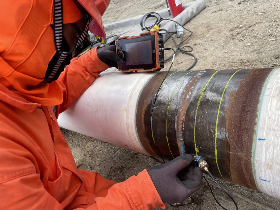 Técnico de IMEXEND inspeccionando con ultrasonido una soldadura de ducto